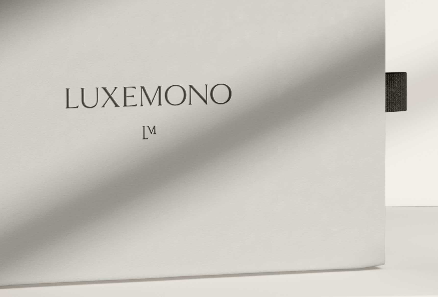 Luxemono's primary logo lockup on mock box packaging